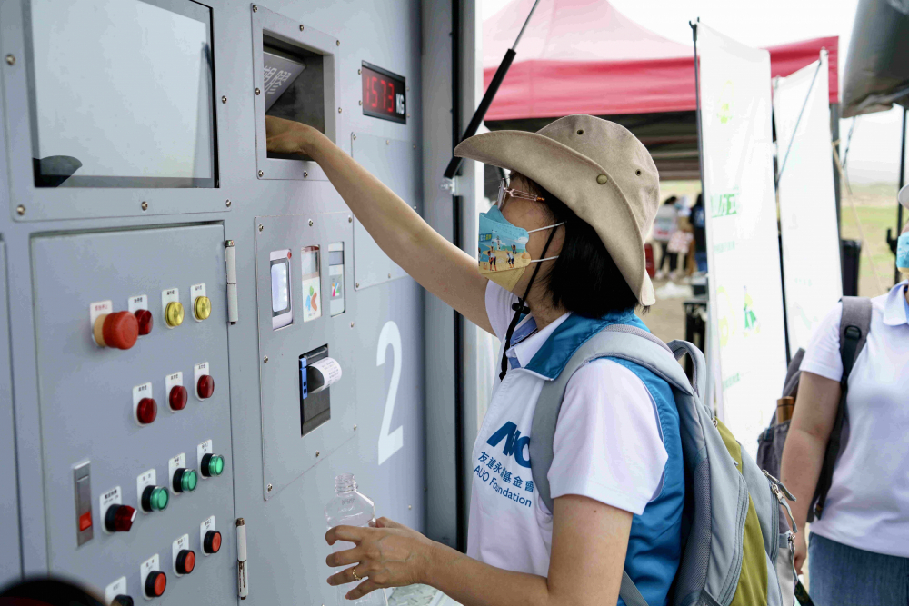 志工們將拾起的寶特瓶投入「好歸塑專車」，讓廢棄塑料空瓶可以直接粉碎、縮小體積，未來將可再製成購物袋、寶特衣、悠遊卡等生活用品